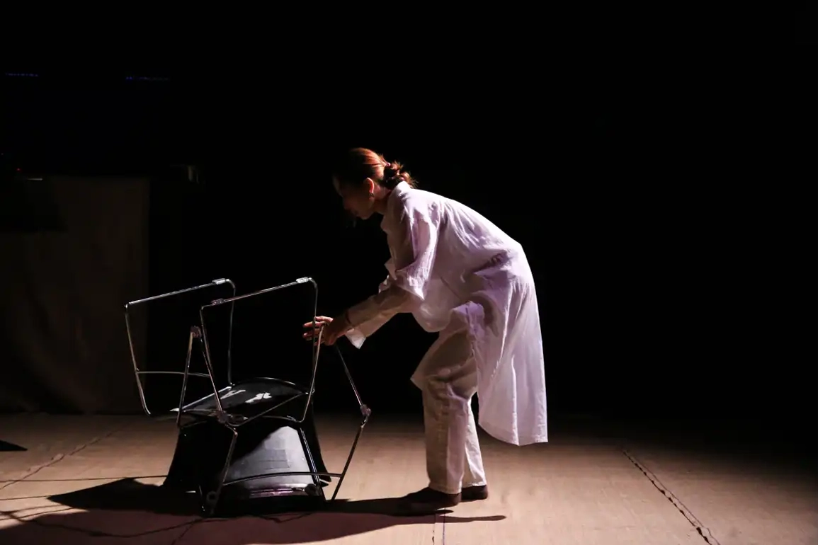 Character holds flipped chair on the floor