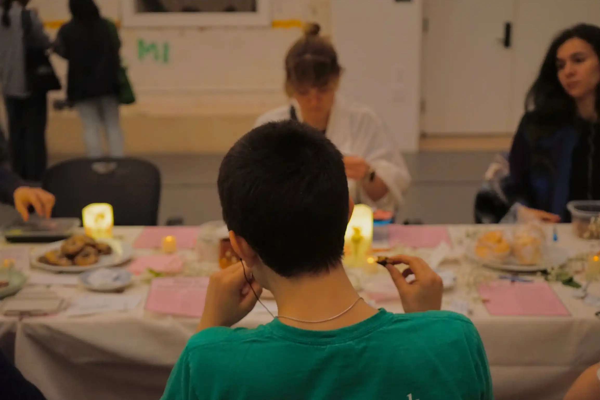 Various attendees wearing headphones, listening to recordings around the dining table